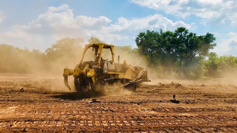 Bulldozer moving earth in a cloud of dust